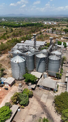 Aerial view of a grain processing plant with large metal storage silos in a rural landscape © Salsabila Ariadina
