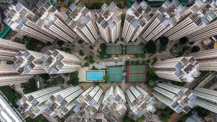Symmetrical top-down view of Hong Kong apartment towers surrounding a courtyard swimming pool © reinaroundtheglobe