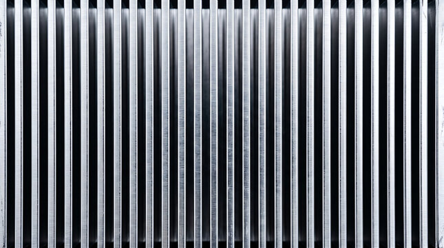 Abstract background of a metallic aluminum heatsink with parallel vertical cooling fins for electronic components