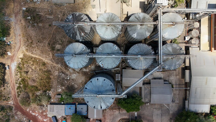 Industrial agricultural complex with large metal grain silos viewed from an aerial perspective © Salsabila Ariadina