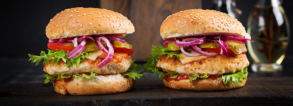 Chicken hamburger. Sandwich with chicken burger, tomatoes, cheese and lettuce. Cheeseburger. Banner