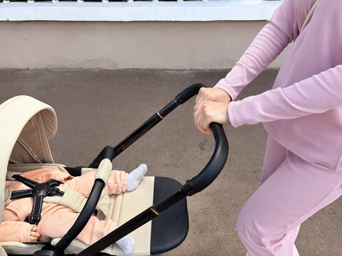 The baby is sleeping in the stroller and is secured with safety straps.