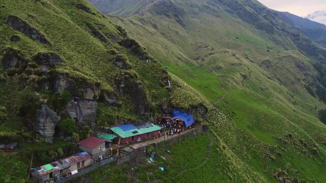 Aerial view of Rudranath Temple nestled on a lush green mountain slope in Gopeshwar Chamoli Uttarakhand