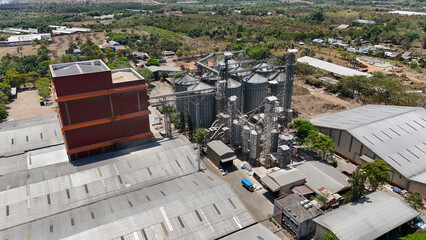Grain processing plant with multiple metal silos and industrial factory buildings from above © Salsabila Ariadina
