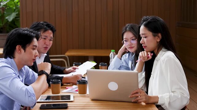 Asian Business Coworkers Meeting and Collaborating with Laptops Outdoors