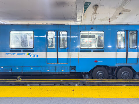 Montreal, Quebec, Canada. September 16, 2026. Side view of a blue STM MR-73 subway train stopped along the station platform track.