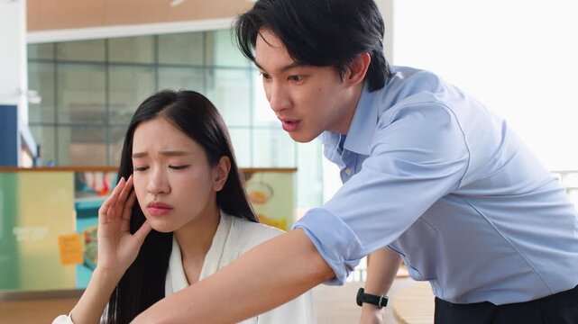 Stressed Asian Coworkers Discussing Work Over Laptop in Office