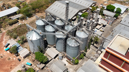 Aerial view of large steel grain silos and industrial processing facility infrastructure © Salsabila Ariadina