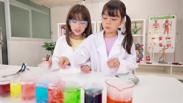 Two Young Schoolgirls Conducting Colorful Dry Ice Science Experiments