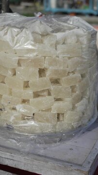 Sweet white petha candy pieces displayed in plastic bag at local market stall