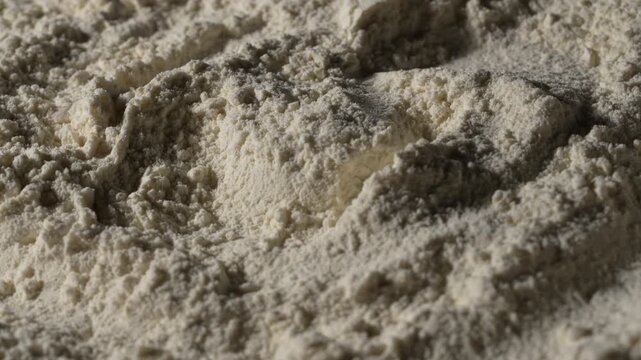 White wheat flour texture abstract macro background, rotates. Close up of organic white flour powder heap with heaps and shadows creating fine culinary texture backdrop