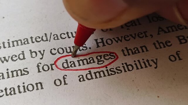 Hand with red ink pen mark circle around to emphasize or highlight damages word on paper. Entrepreneur person or businessman focus on making decision on business damage control.