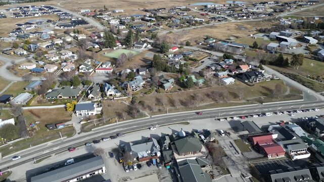 Beautiful aerial view of Tekapo town and Lake Tekapo in New Zealand surrounded by dramatic mountains, natural scenery, residential streets and iconic tourist landmarks