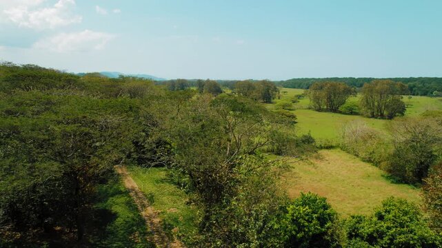 Lush tropical forest and open fields seen from above in Costa Rica