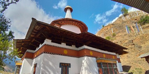 ブータンのパロにある歴史的な仏教寺院キチュ・ラカンの建物と青空 © Zumi