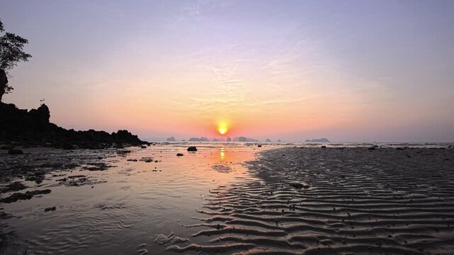Sunrise on a sandy beach at low tide on a tropical island in Phang Nga Bay, Thailand