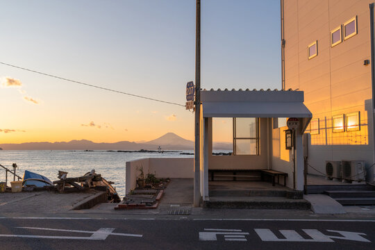 葉山町の真名瀬バス停と富士山を望む夕暮れの海岸風景
