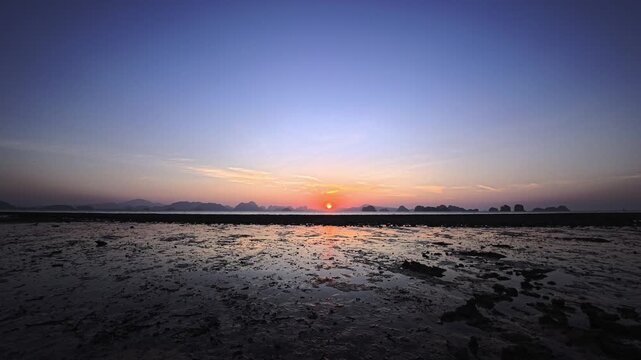 Sunrise on a sandy beach at low tide on a tropical island in Phang Nga Bay, Thailand