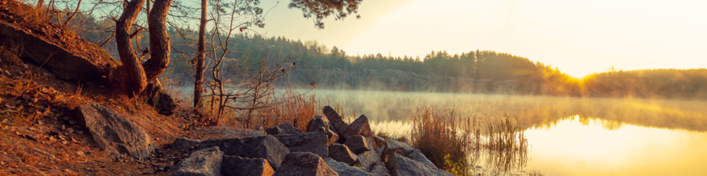 Rocky shore of the mountain lake in the misty autumn morning. Beautiful nature of Norway. Reflection on the lake