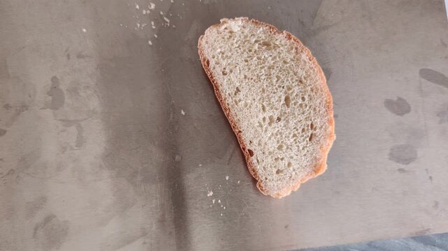 Woman's hand taking a fresh loaf of bread out of the kitchen frame