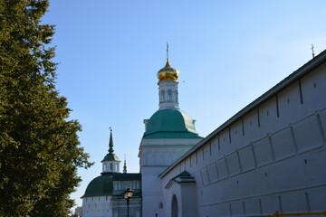 Golden domes shine under clear blue sky at historic monastery in Russia © Alexander