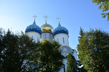 Church with blue domes and golden structure in a clear sky © Alexander