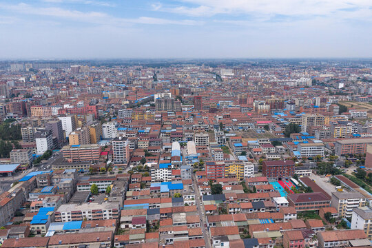 Aerial view of small Chinese city with dense residential buildings under blue sky