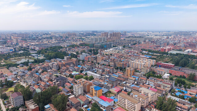 Aerial view of small Chinese city with dense residential buildings under blue sky