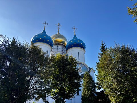 Church with blue domes and golden dome under clear sky
