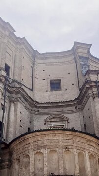 Vertical low-angle view of the rear apse of Parma Cathedral in Italy, showing massive Romanesque brickwork, curved walls, pilasters and weathered medieval masonry.