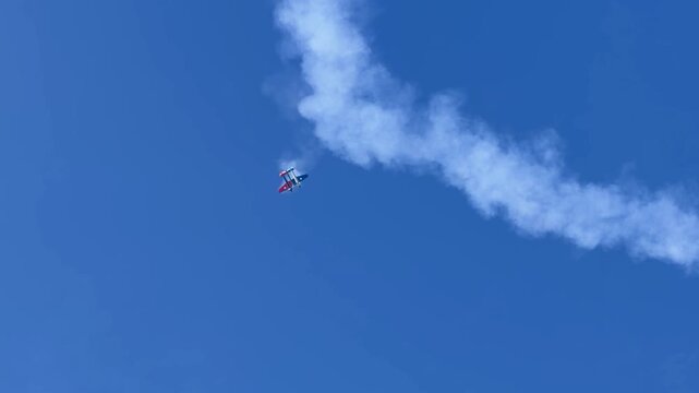 Stunt Plane Performing Aerobatic Maneuvers with Smoke Trails at Gold Coast