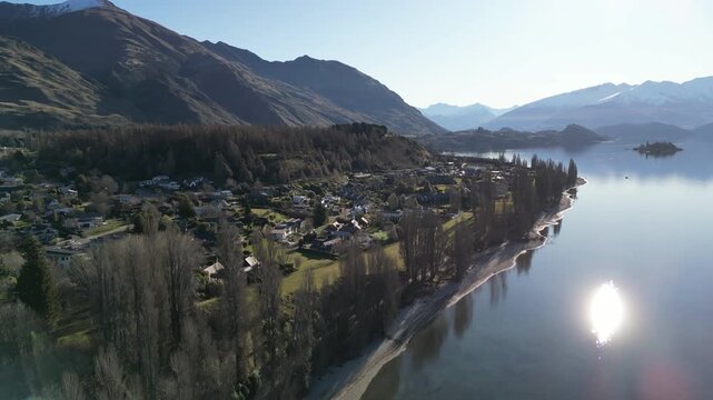 Southern Alps mountains dominate the scenic Lake Wanaka landscape in New Zealand with beautiful natural ranges and tranquil Pacific island scenery attracting travel and tourism