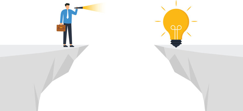 A businessman standing on a cliff edge looking through a telescope at a glowing light bulb across a gap representing business innovation and problem solving.