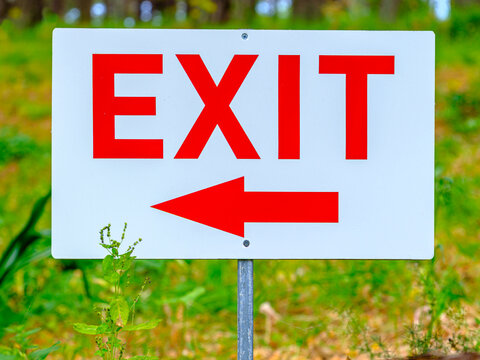 Schild mit roter Aufschrift EXIT und einem Pfeil nach links