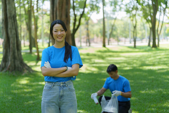 Asian woman volunteer standing in park during community environmental cleanup project
