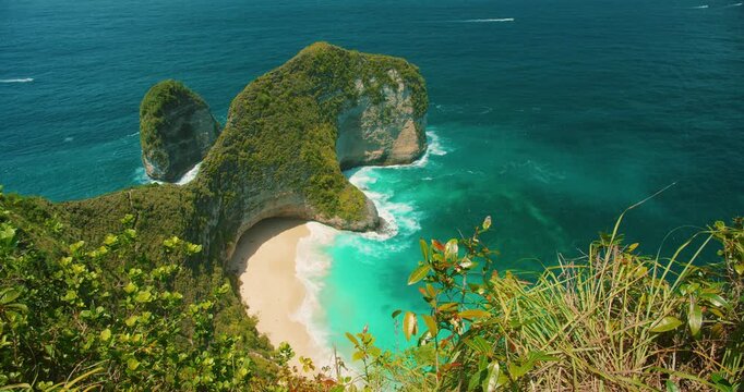 Sunlit view of Kelingking Beach cliffs and vibrant turquoise ocean Nusa Penida