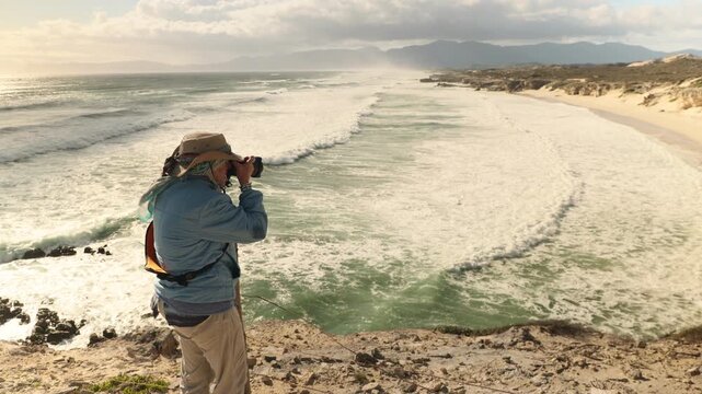 female photographer wearing backpack photographing Walker Bay Nature Reserve, South Africa