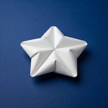 Minimalist white paper star shape origami on a dark blue background with folded paper craft minimalist decor geometric shape paper sculpture handmade star paper art