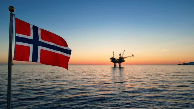 Norwegian flag waving over north sea oil platform at sunset energy industry and offshore drilling concept