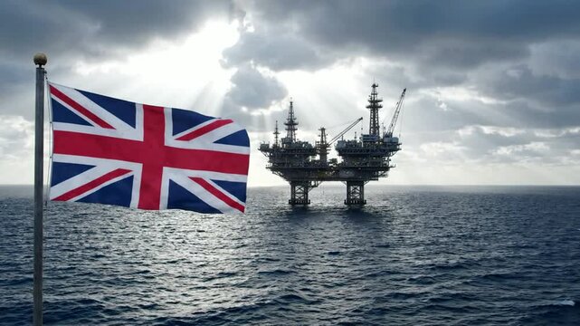 British flag waving against offshore oil rig platform in north sea at sunset united kingdom britain union jack