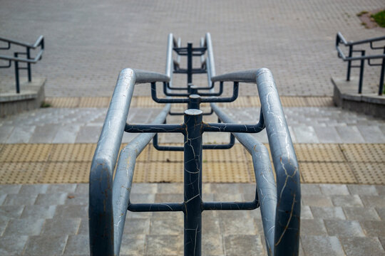 High angle view of metal handrail on outdoor concrete stairs with tactile paving for accessibility
