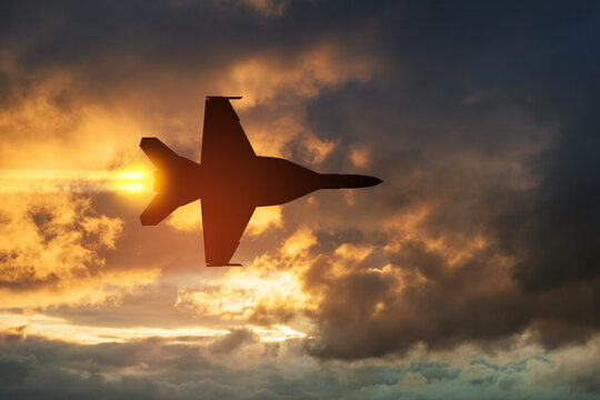 Air Force Day. Aircraft silhouette on background of sunset. Combat flight of interceptor on a mission.
