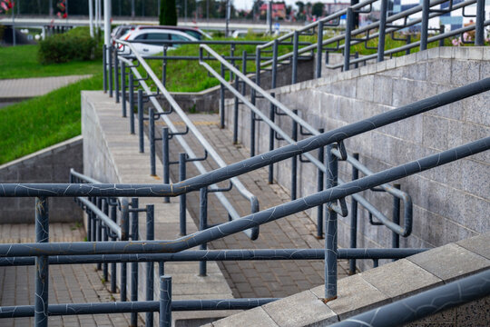 Concrete accessibility ramps with metal handrails creating barrier free environment for disabled people in city