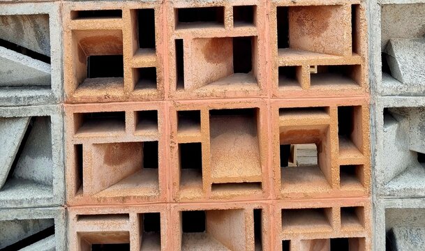 Ventilation blocks in a concrete wall, featuring geometric patterns designed for airflow, natural lighting, privacy, and building facade design.