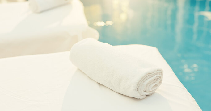 Spa, empty and towel on bed at resort for pamper, beauty treatment and calm for wellness retreat. Hospitality, background and massage table for stress relief, holistic therapy and skincare by pool