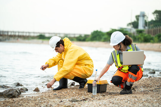 A team collects water and soil samples along a polluted riverbank to check for contamination and environmental issues, focusing on ecological protection and pollution control.
