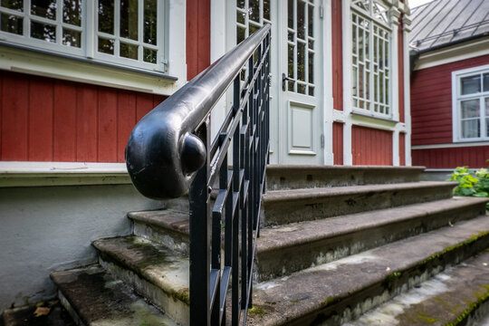 Stone Steps and Black Railing at Traditional Red Wooden Building