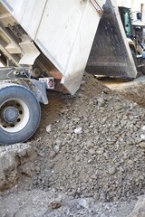Dump truck unloading gravel at construction site © Анна Хмеленок