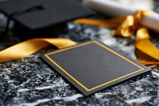 Sophisticated ceremony program layout with blank cover, black graduation cap, diploma and satin ribbon arranged on polished marble, luxury stationery concept, bright natural lighting, no people