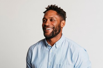 Obraz premium Smiling adult man with beard and short hair wearing light blue button down shirt studio portrait